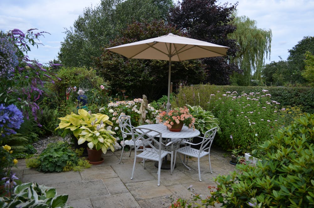 English country garden with sandstone patio and herbaceous borders