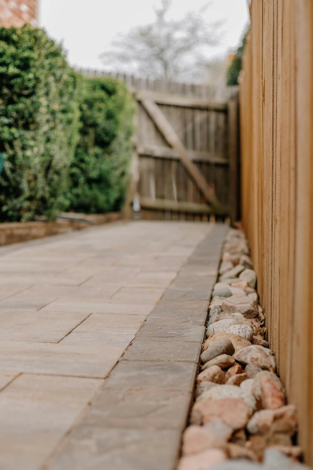 Indian sandstone patio with gravel drainage border and new fence